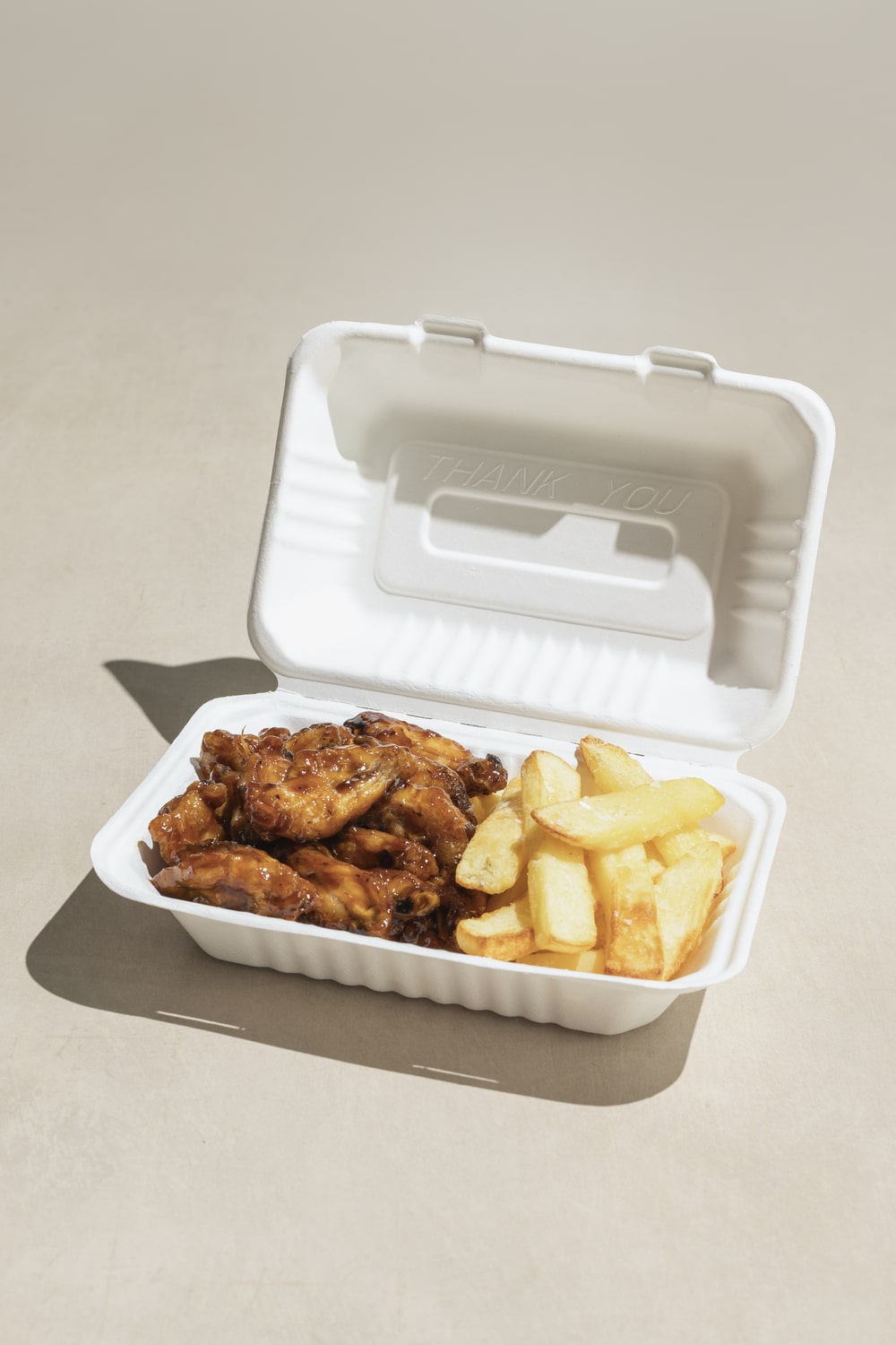 Yucca Packaging 1000ml bagasse sugarcane clamshell packed with wings and chips.
