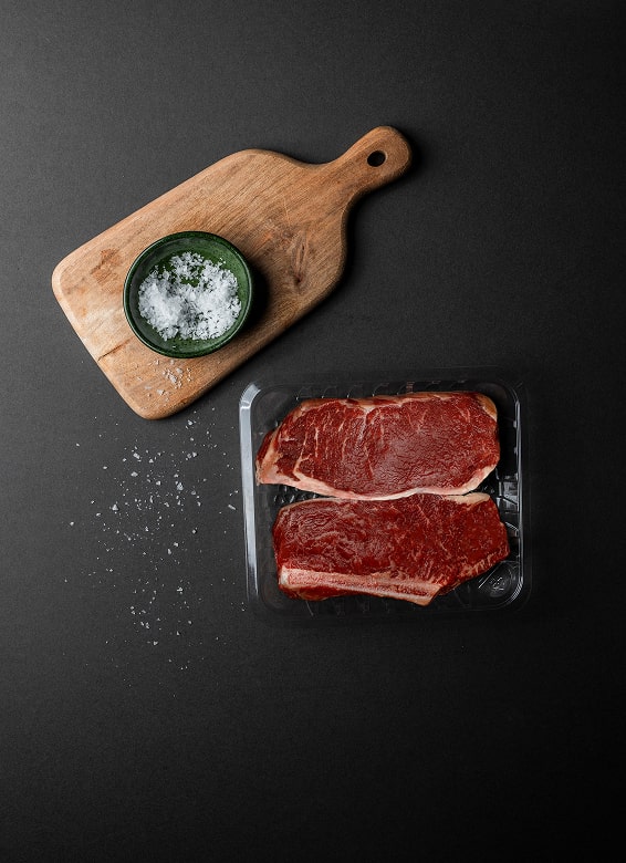 Yucca Packaging purge-lock open cell tray packed with thinly sliced steaks.